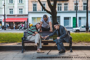 Lviv, Ukrayna - 3 Ağustos 2019 - Kentin bank parkında satranç oynayan yaşlılar