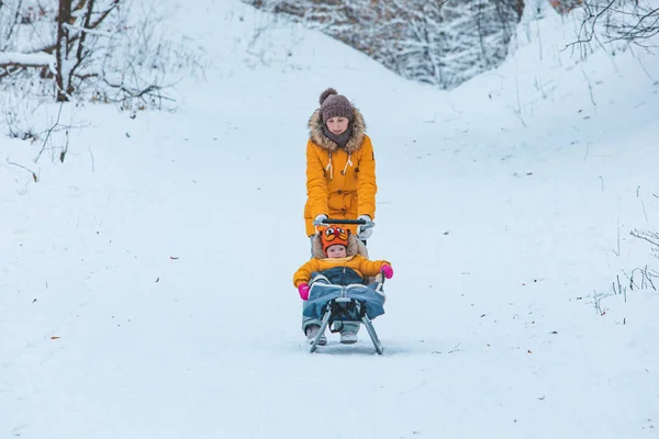 冬の丘から滑り降りてくる娘さんと — ストック写真