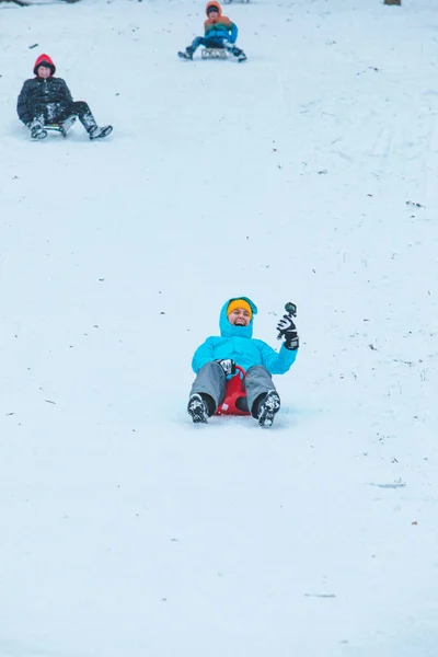 Jonge vrouw glijden door besneeuwde heuvel — Stockfoto