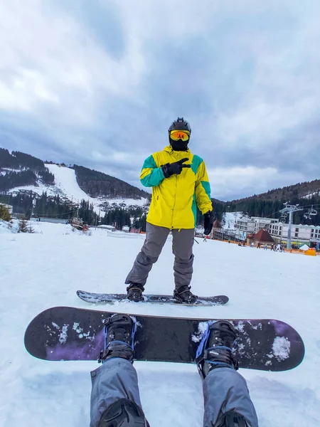 Pareja sentada en la colina nevada con snowboard. actividades de invierno —  Fotos de Stock