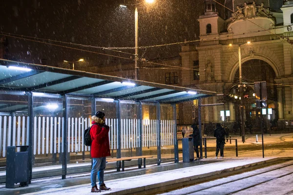 Adam kışın karlı bir gecede tren istasyonunda tramvayı bekliyordu. — Stok fotoğraf