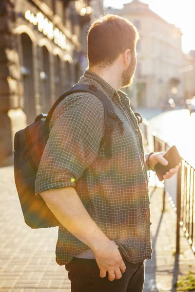 Молодой бородатый мужчина на закате городской улицы — стоковое фото
