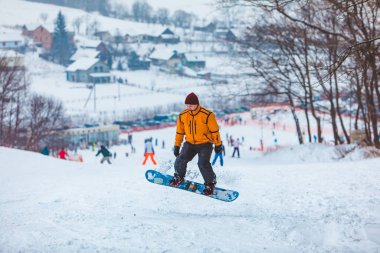Tepenin aşağısında snowboard yapan bir adam