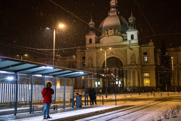 Uomo in inverno nevicato notte alla stazione ferroviaria in attesa di tram — Foto Stock