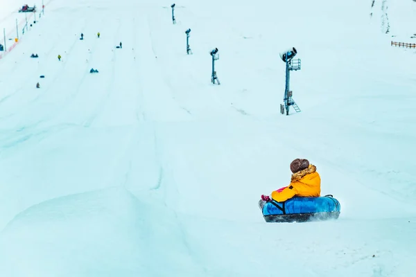 Lviv, Ουκρανία - 7 Ιανουαρίου 2019: Χειμερινές διασκεδαστικές δραστηριότητες. βόλτα κάτω από το λόφο με σωλήνα χιονιού — Φωτογραφία Αρχείου
