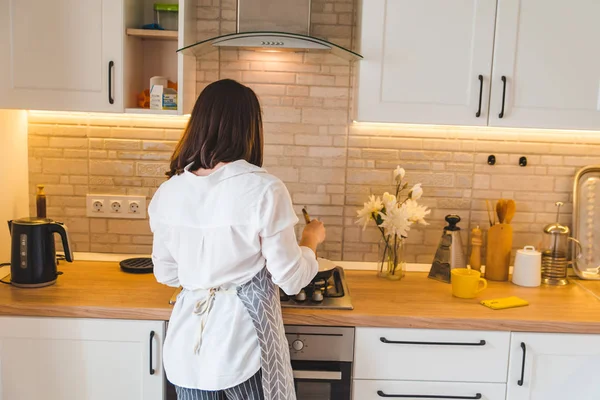 Uitzicht vanaf achter vrouw op keuken koken — Stockfoto