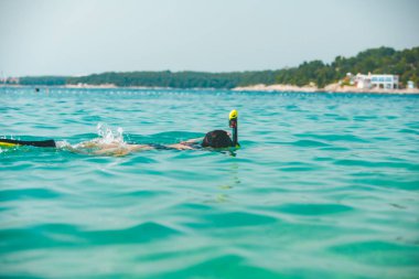 Deniz suyunda şnorkelli bir kadın.