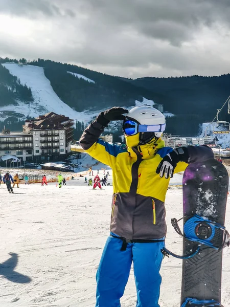 Mujer de pie en la colina de la estación de esquí con snowboard —  Fotos de Stock