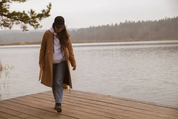Autunno lago stagione donna in cappotto al molo di legno — Foto Stock