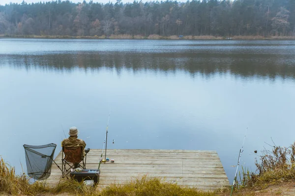 Pescador pescando en tranquilo lago de otoño — Foto de Stock