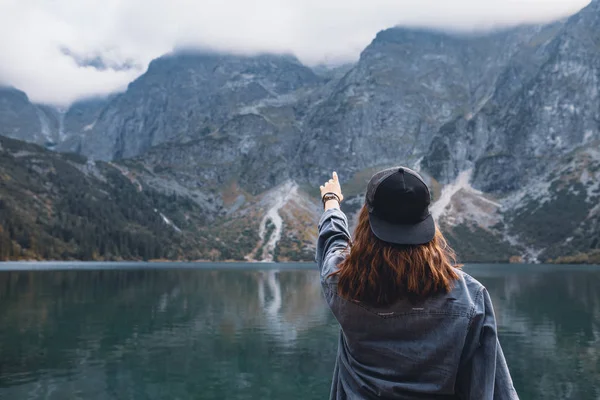 Mulher tentando alcançar a vista paisagem céu do lago em montanhas — Fotografia de Stock