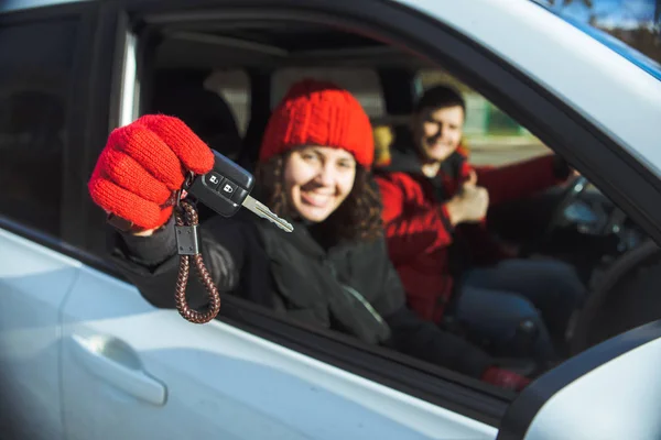 Casal sentado no carro mulher segurando chave do carro na mão — Fotografia de Stock