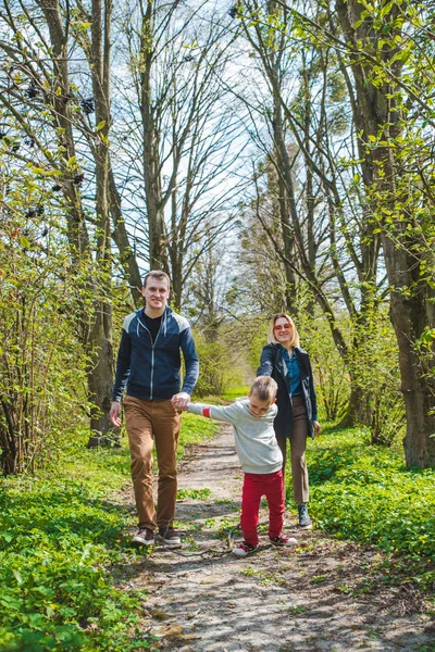 Familia de tres caminando por el sendero del parque en día soleado —  Fotos de Stock