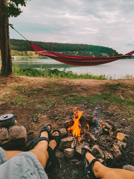 Couple se reposant près du feu de camp en regardant le lac — Photo