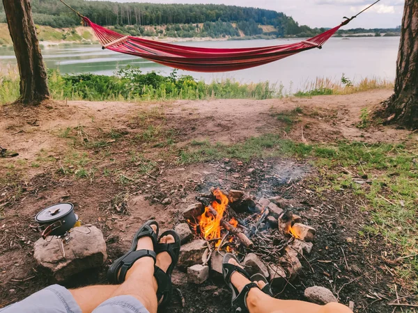 Couple resting near campfire looking at lake — 스톡 사진