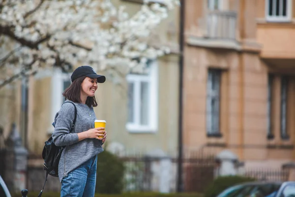 Young stylish woman walking by street with coffee cup — Stock Photo, Image