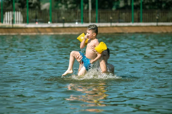 Father throwing son in water having fun — Stock Photo, Image