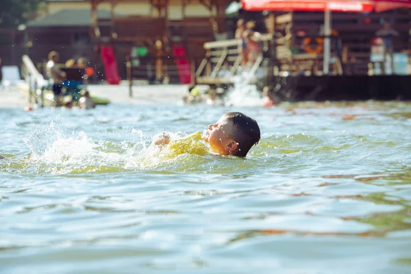 Little toddler kid swimming in lake with inflatable arms aids support — Stock Photo, Image