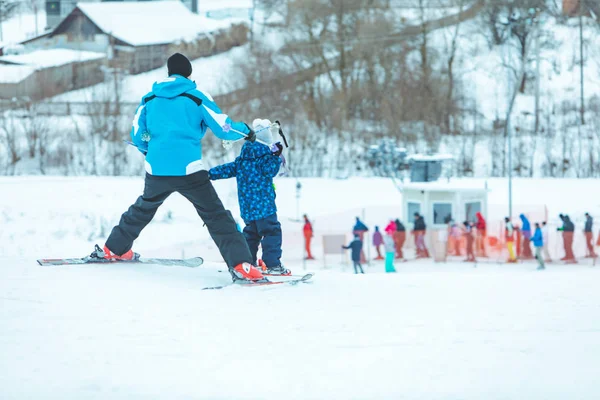 Kleine jongen met stokken van de instructeur. skiën leren — Stockfoto