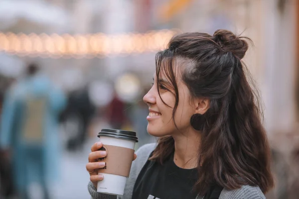 Young pretty woman at city street drinking coffee from disposable cup — Stock Photo, Image