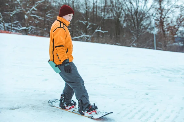 Fiatal férfi lovaglás snowboard a téli dombon — Stock Fotó