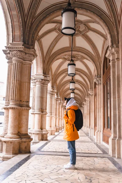 Mulher turista caminhando com mochila em amarelo capa de chuva turismo da cidade — Fotografia de Stock