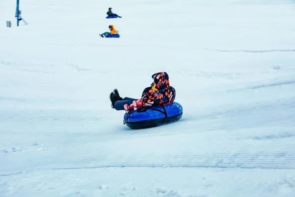 LVIV, UKRAINE - January 7, 2019: family ride down by snowing hill with snow tube — Stock Photo, Image