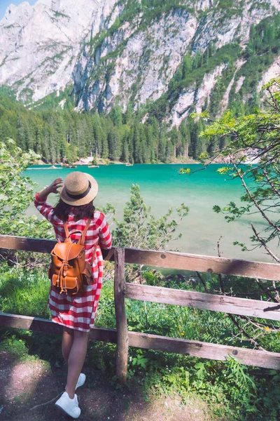 Mulher de pé em frente ao lago nas montanhas — Fotografia de Stock