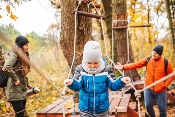 Heureux jeune famille avec tout-petit enfant fils jouer à aire de jeux — Photo