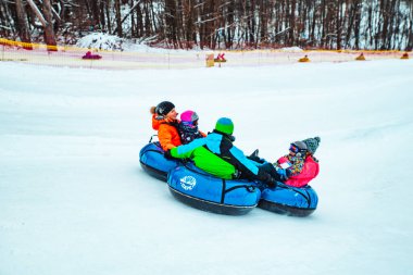 Lviv, Ukrayna - 7 Ocak 2019: Aile gezisi kar tübü ile kar tepesinde