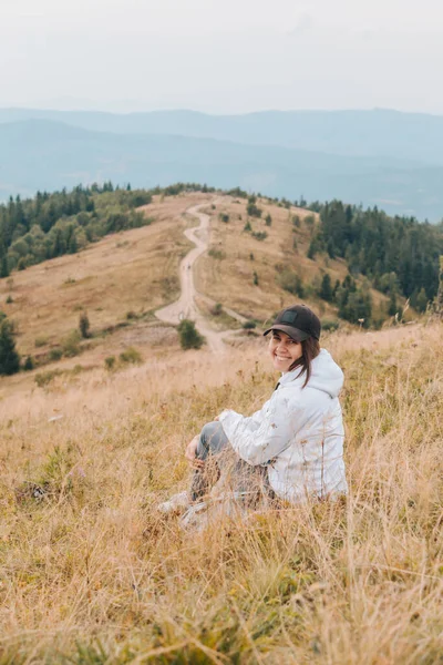 Donna seduta a terra guardando montagna escursionismo concetto — Foto Stock