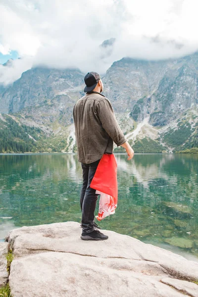 Adamın biri Tatra dağlarındaki göle bakarken cebinde Polonya bayrağı vardı. — Stok fotoğraf