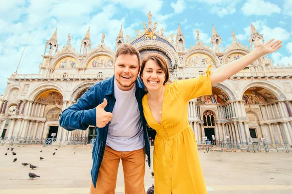 Молодая красивая пара позирует перед святыми марками базилики Venice italy — стоковое фото