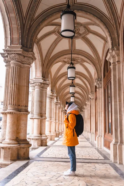 Turista mujer caminando con mochila en impermeable amarillo turismo de ciudad — Foto de Stock