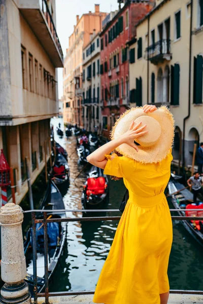 Frau in gelbem Kleid an Brücke mit Blick auf Kanal von Venedig — Stockfoto