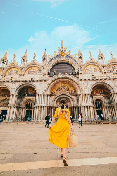 Mulher em sundress amarelo com chapéu de palha andando para santo marca basílica — Fotografia de Stock