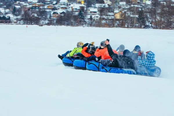 Familienfahrt mit Schneeschlauch durch verschneiten Hügel — Stockfoto