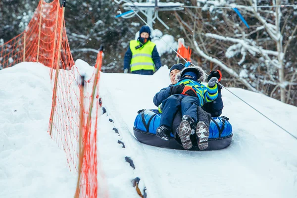 Père avec fils sur tube à neige. monter à la colline — Photo