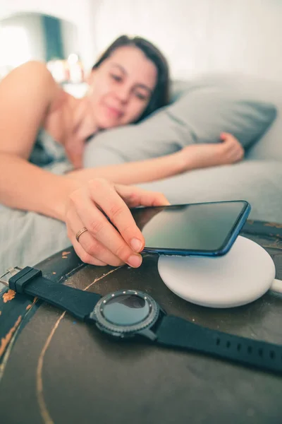 Woman put cellphone for charging on wireless charge — Stock Photo, Image