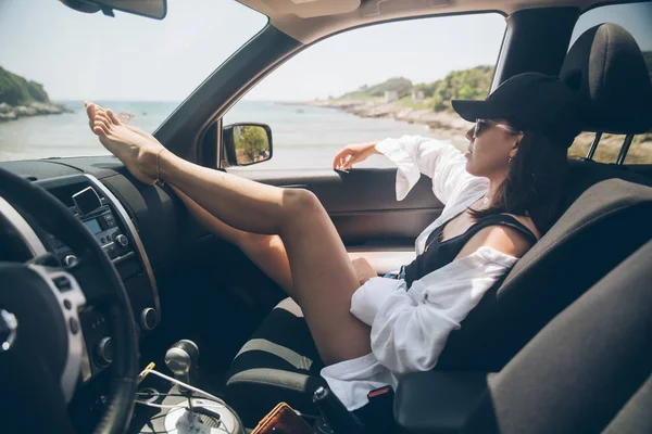 Frau sitzt im Auto zeigen sexy Beine Blick auf Sommer Meer Strand — Stockfoto