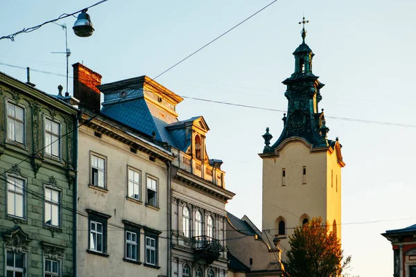 Kilátás a város főterén templom torony naplementekor — Stock Fotó