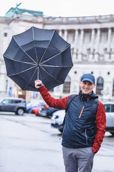 Mann mit Regenschirm vom Wind verwirbelt — Stockfoto