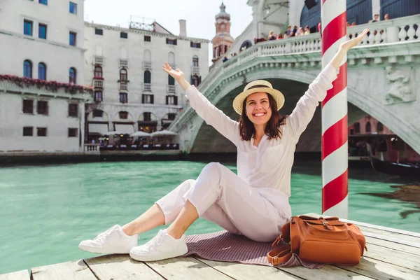 Mujer sentada cerca de puente de rialto en Venecia mirando a Gran Canal con góndolas — Foto de Stock