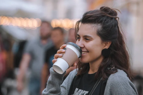 Young pretty woman at city street drinking coffee from disposable cup — Stock Photo, Image