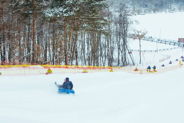 Menschen, die Spaß haben. Snowtubing durch den Winterberg — Stockfoto