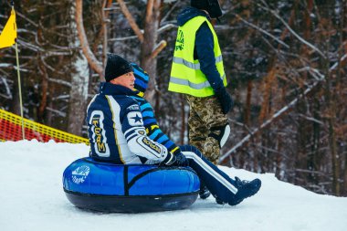 Lviv, Ukrayna - 7 Ocak 2019: Aile gezisi kar tübü ile kar tepesinde