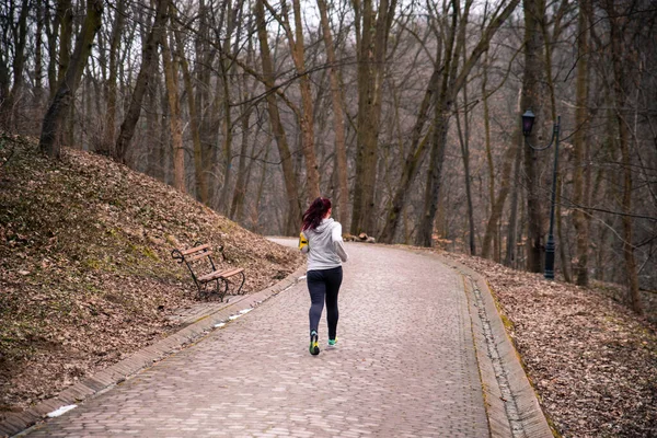 Femeie alergând alergând prin parcul de iarnă — Fotografie, imagine de stoc