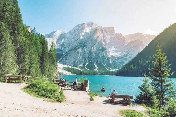 Homem sentado no banco desfrutando da vista do lago nas montanhas — Fotografia de Stock