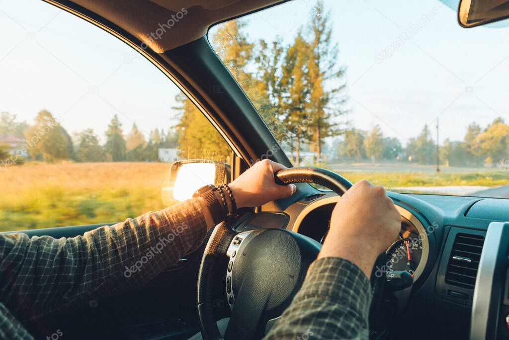 car travel concept man hand on steering wheel speedway