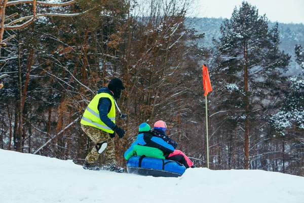 Atividades divertidas de inverno. passeio para baixo pela colina na tubulação de neve — Fotografia de Stock